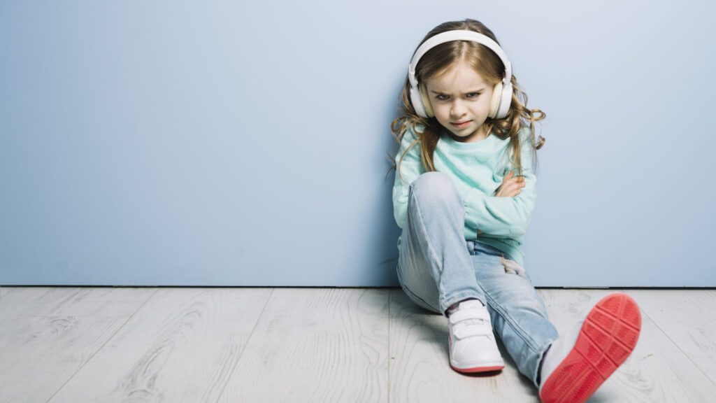 portrait-angry-girl-listening-music-headphone-looking-camera